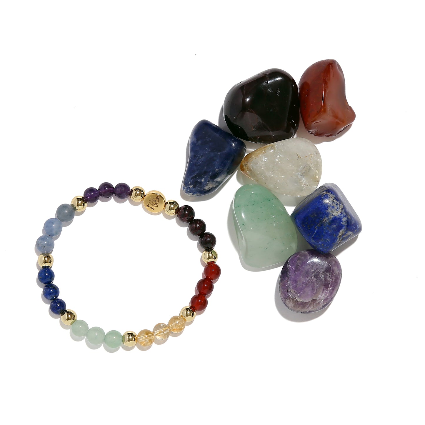 Multicolored beaded bracelet next to unpolished gemstones on a white background